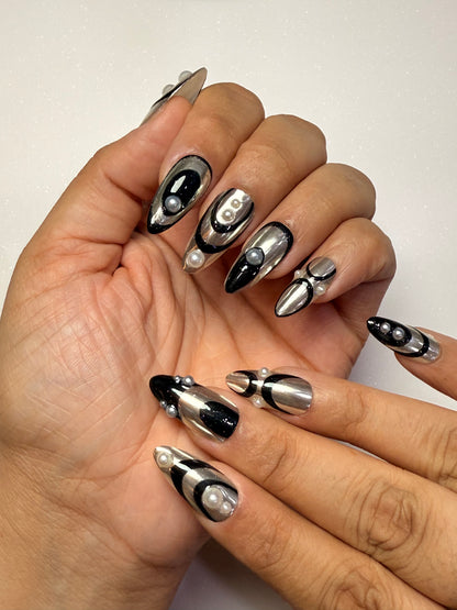 Close-up of hands with black and silver nail art on a neutral background silver chrome nail set abstract nail set 