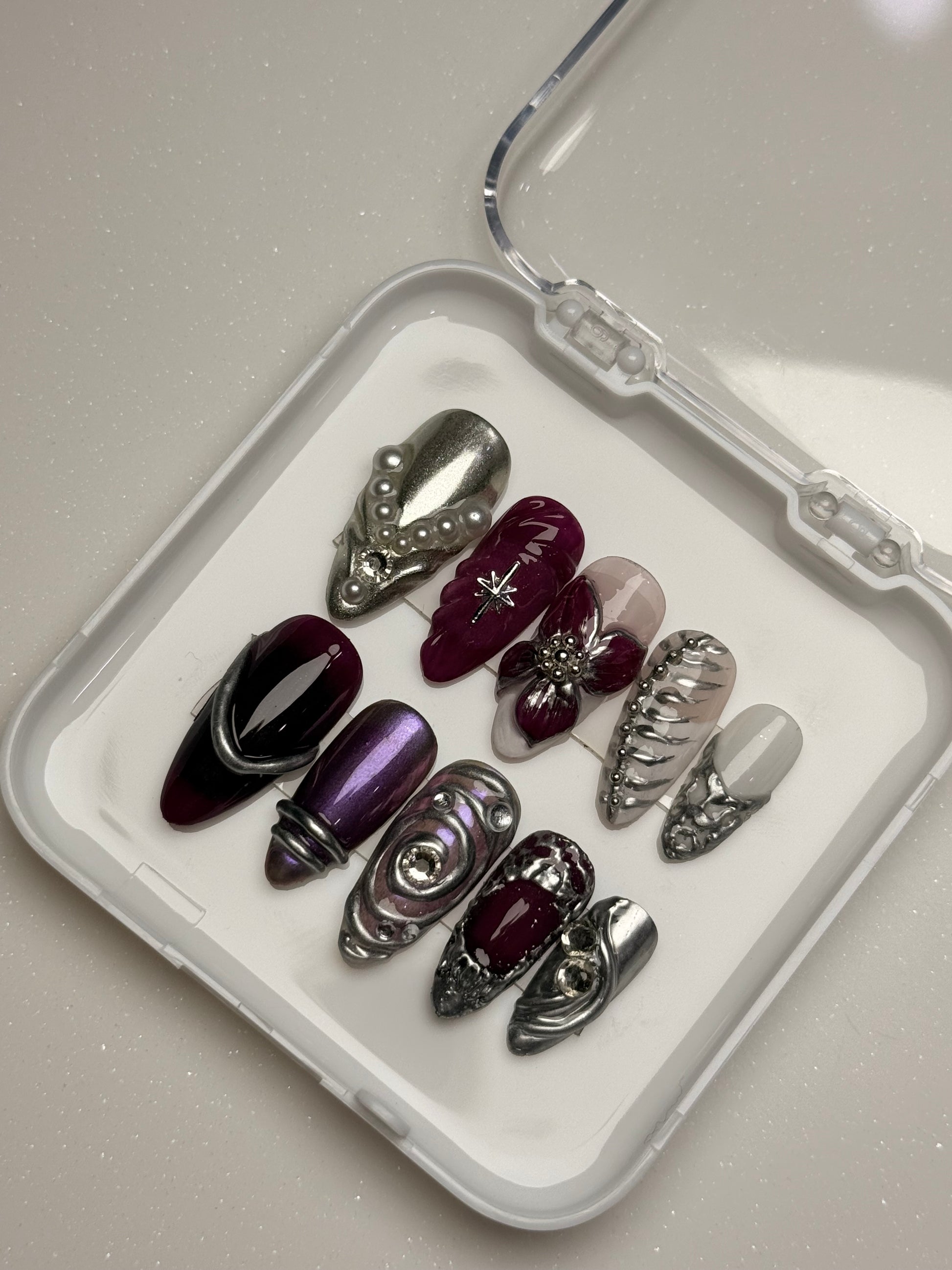 Set of purple and silver hair clips on a white tray with a clear lid chrome nail set 3D flower nail set  purple nail set