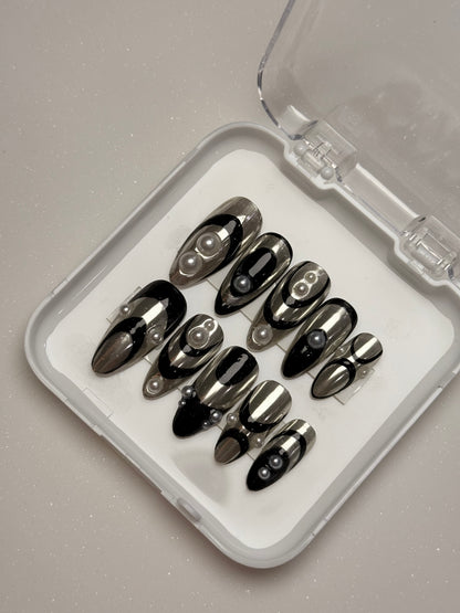 Set of black nail tips in a clear case on a gray background silver chrome nail set abstract nail set 