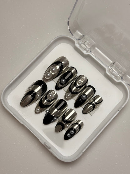 Set of black stiletto nails in a clear case on a gray background silver chrome nail set abstract nail set 