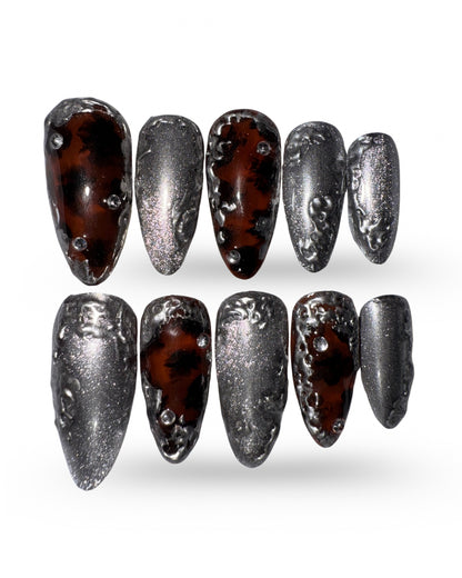 Set of nail art designs with metallic and tortoiseshell patterns on a white background