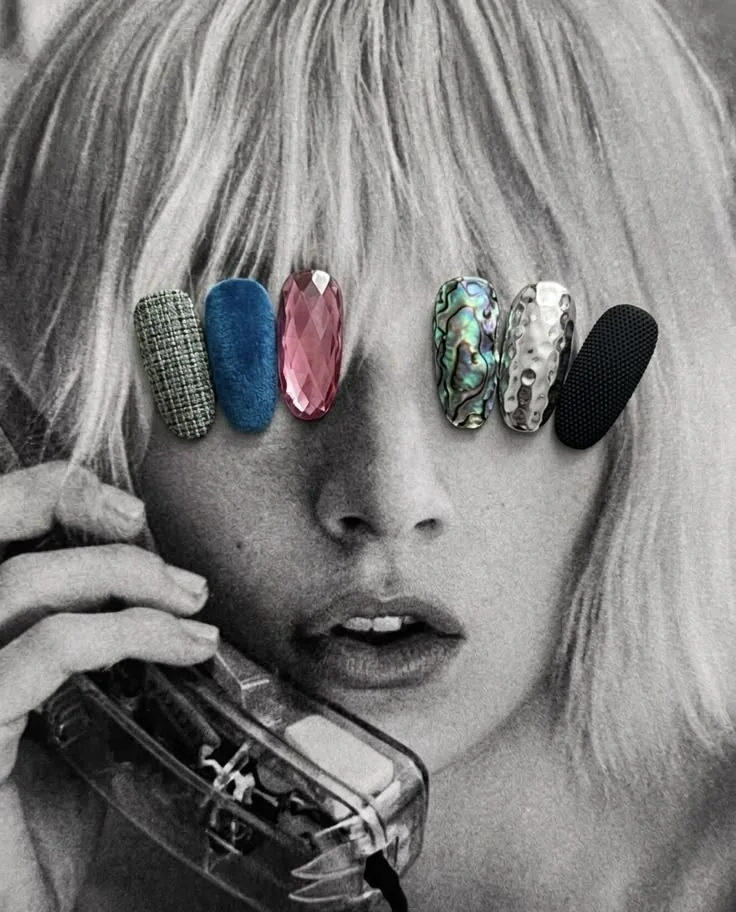 Black and white portrait with a row of textured nail swatches, tweed, velvet, faceted gem, abalone, hammered silver, laid across the eyes